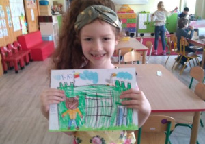 Dziewczynka z rysunkiem zamku Misia Uszatka